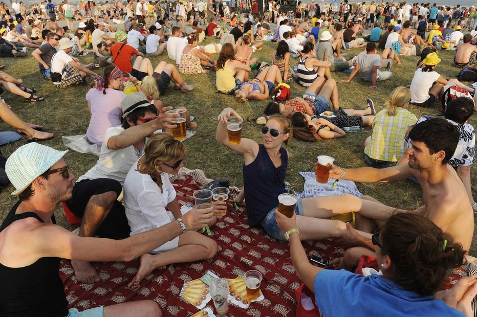 Revellers drink beer during the Pohoda music festival at Trencin airport, 130 km (81 miles) north of Bratislava, July 7, 2012. Pohoda, the largest Slovak open-air music festival, is attended by almost 30,000 visitors. REUTERS/Radovan Stoklasa (SLOVAKIA - Tags: SOCIETY ENTERTAINMENT)
