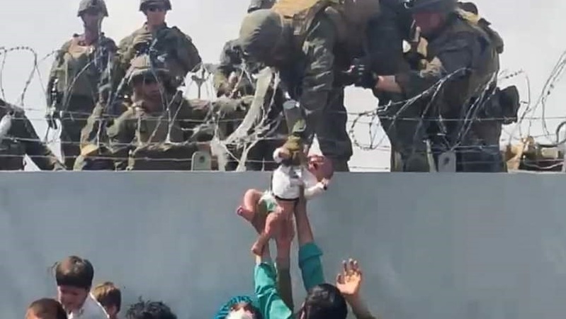 Imagem de bebê entregue a um soldado no muro do aeroporto de Cabul, em meio aos arames farpados, choca, emociona e viraliza