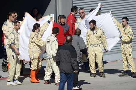 Equipe da McLaren cobre Alonso enquanto o piloto é levado a helicóptero Foto: Manu Fernandez / AP