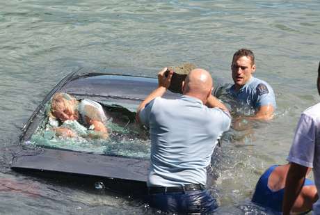 A mulher foi resgatada pela janela traseira do veículo após ela ser quebrada com uma rocha Foto: Daily Mail / Reprodução